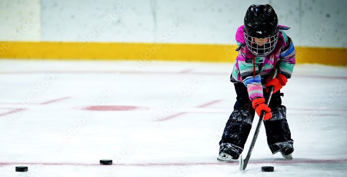 Child with hockey pucks lined up