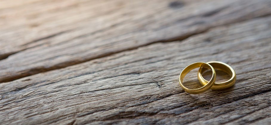 two gold rings on wooden table